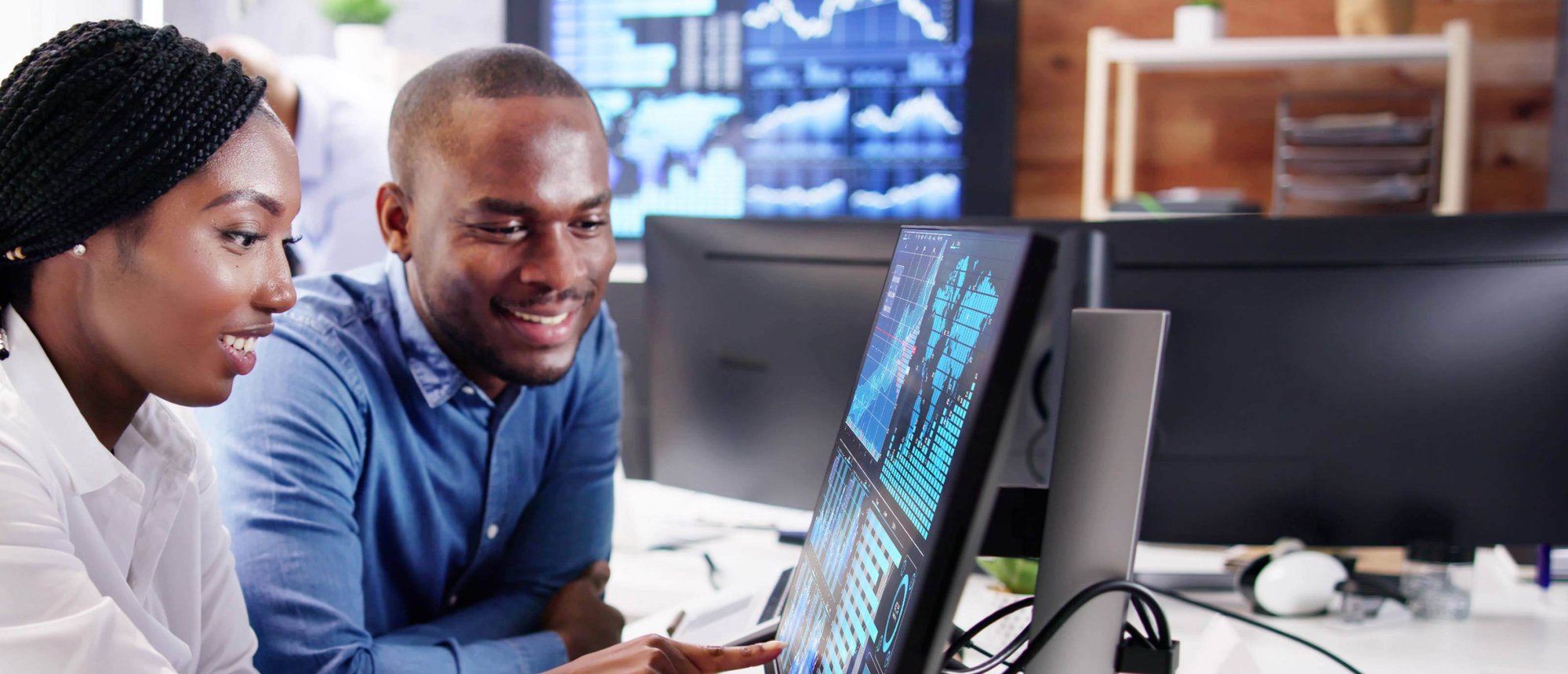 Man and woman looking at data on computer screen