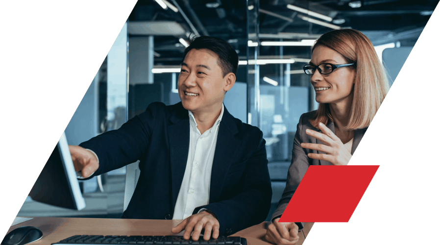 Man and woman in suits looking at monitor together