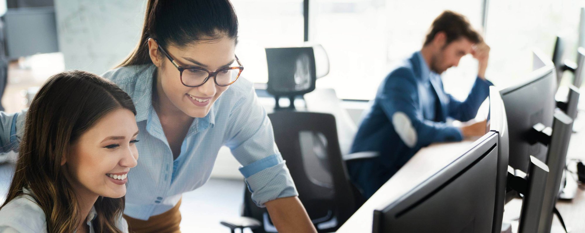 Two woman looking at computer screen together