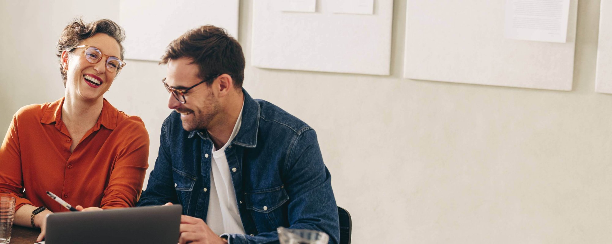 Woman and man and smiling and talking with laptop