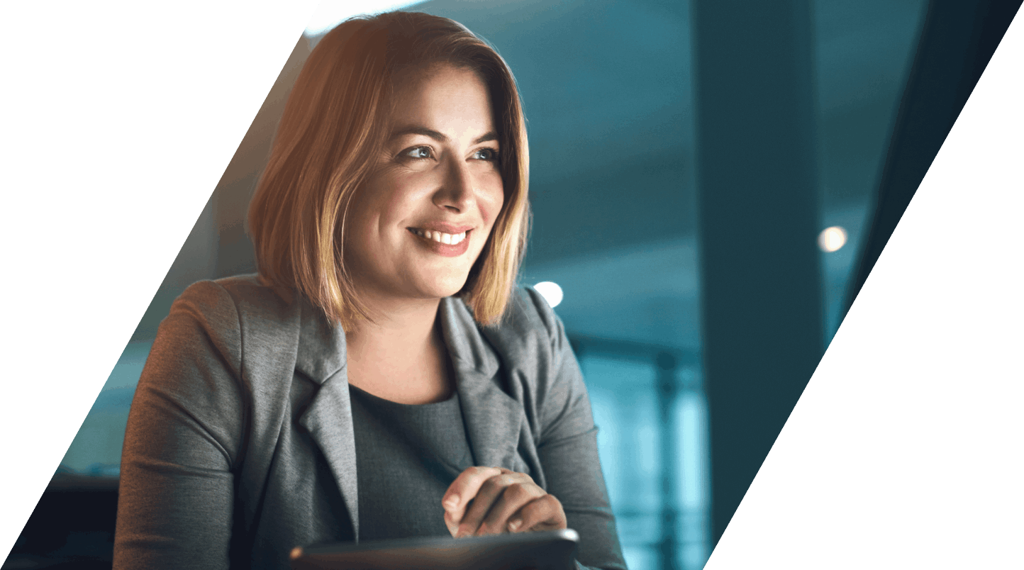 Happy woman in suit holding tablet looking at screen