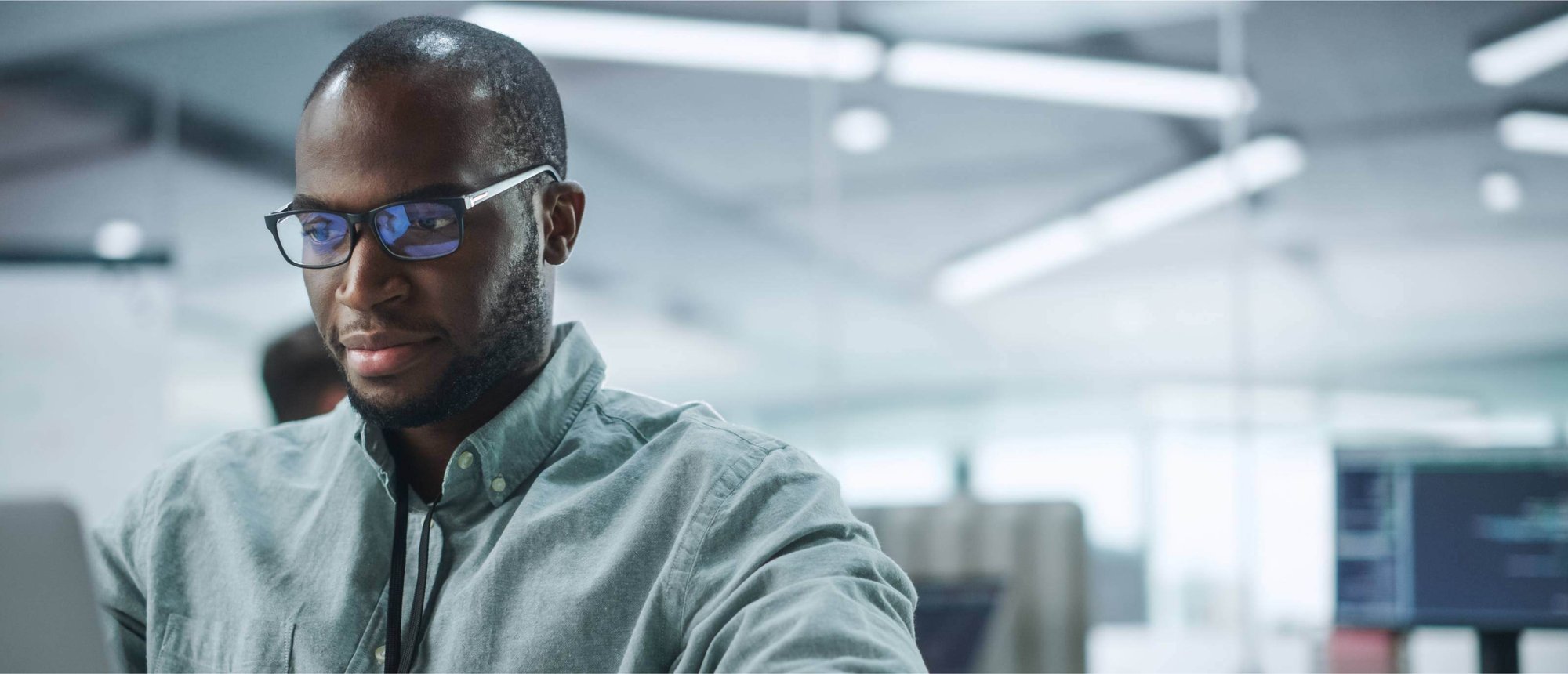 Man with glasses looking at laptop screen