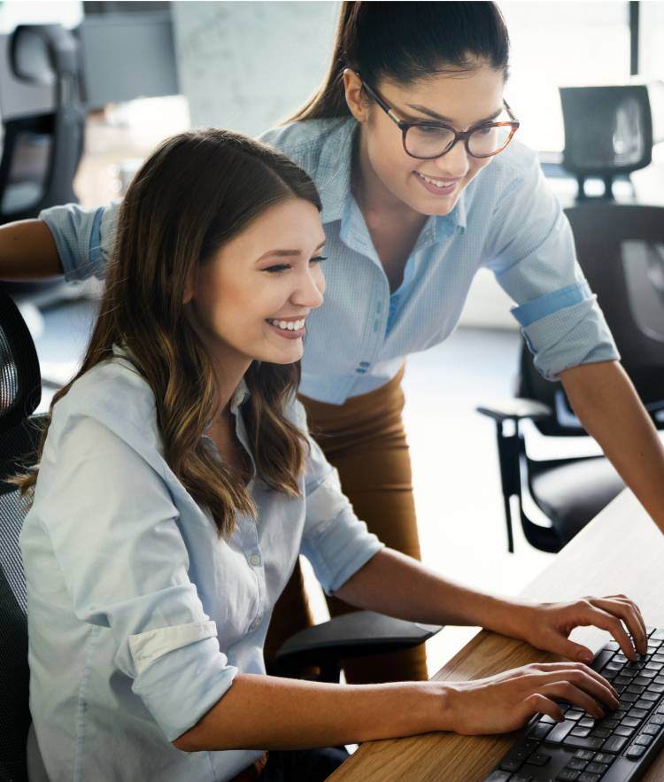 Two woman looking at computer screen together-mobile