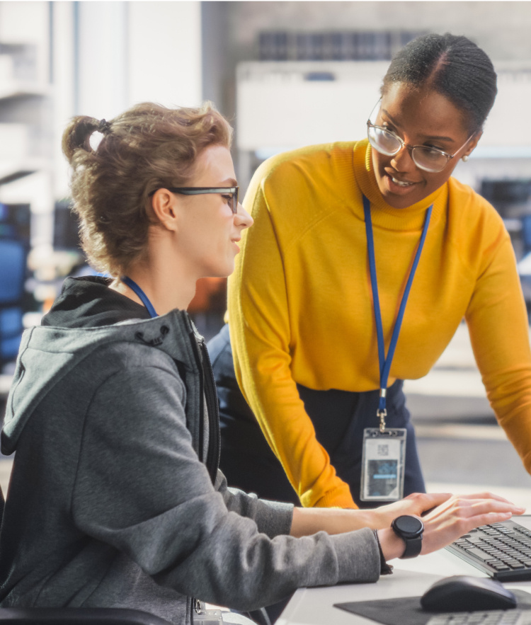 Two women talking with computer showing data-mobile